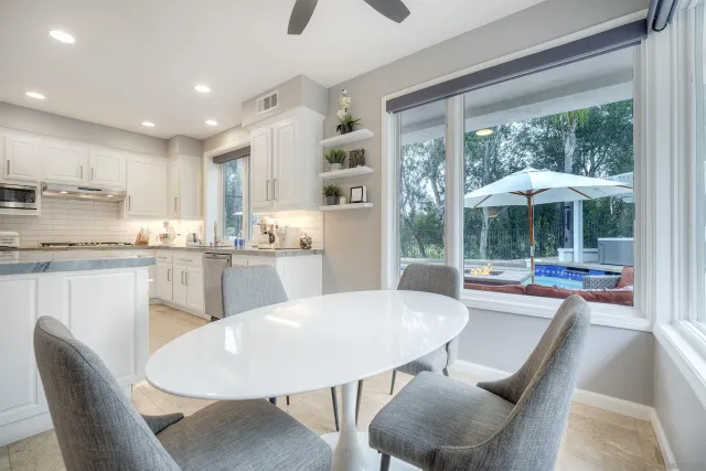 a dining room with furniture and a floor to ceiling window