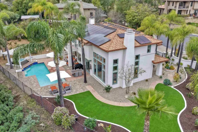 a view of a house with a yard chairs and table in patio