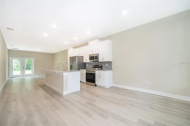 a kitchen with granite countertop a stove top oven and cabinets