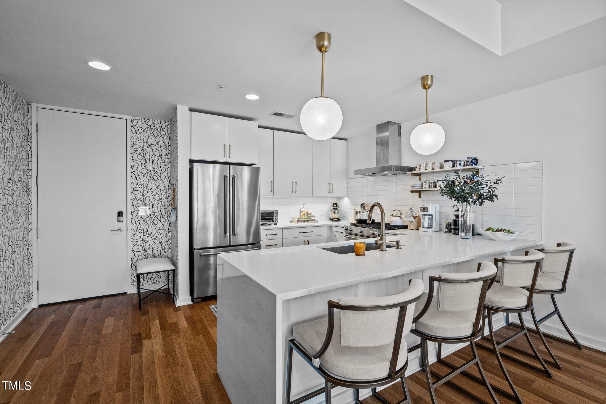 523 South West Street, Unit 304 Raleigh, NC 27601 - Photo 2 of 23 a kitchen with stainless steel appliances granite countertop a dining table chairs stove refrigerator and microwave