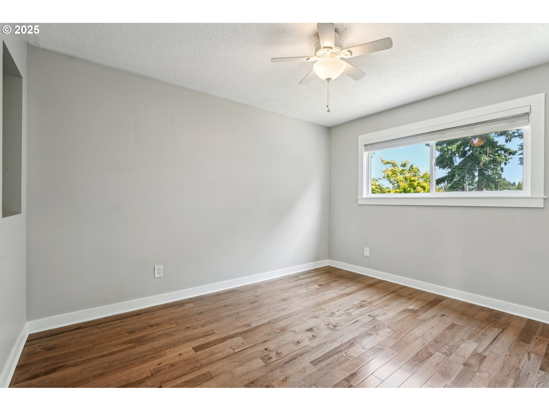 704 Southeast 207th Avenue Gresham, OR 97030 - Photo 13 of 35 an empty room with wooden floor and a ceiling fan