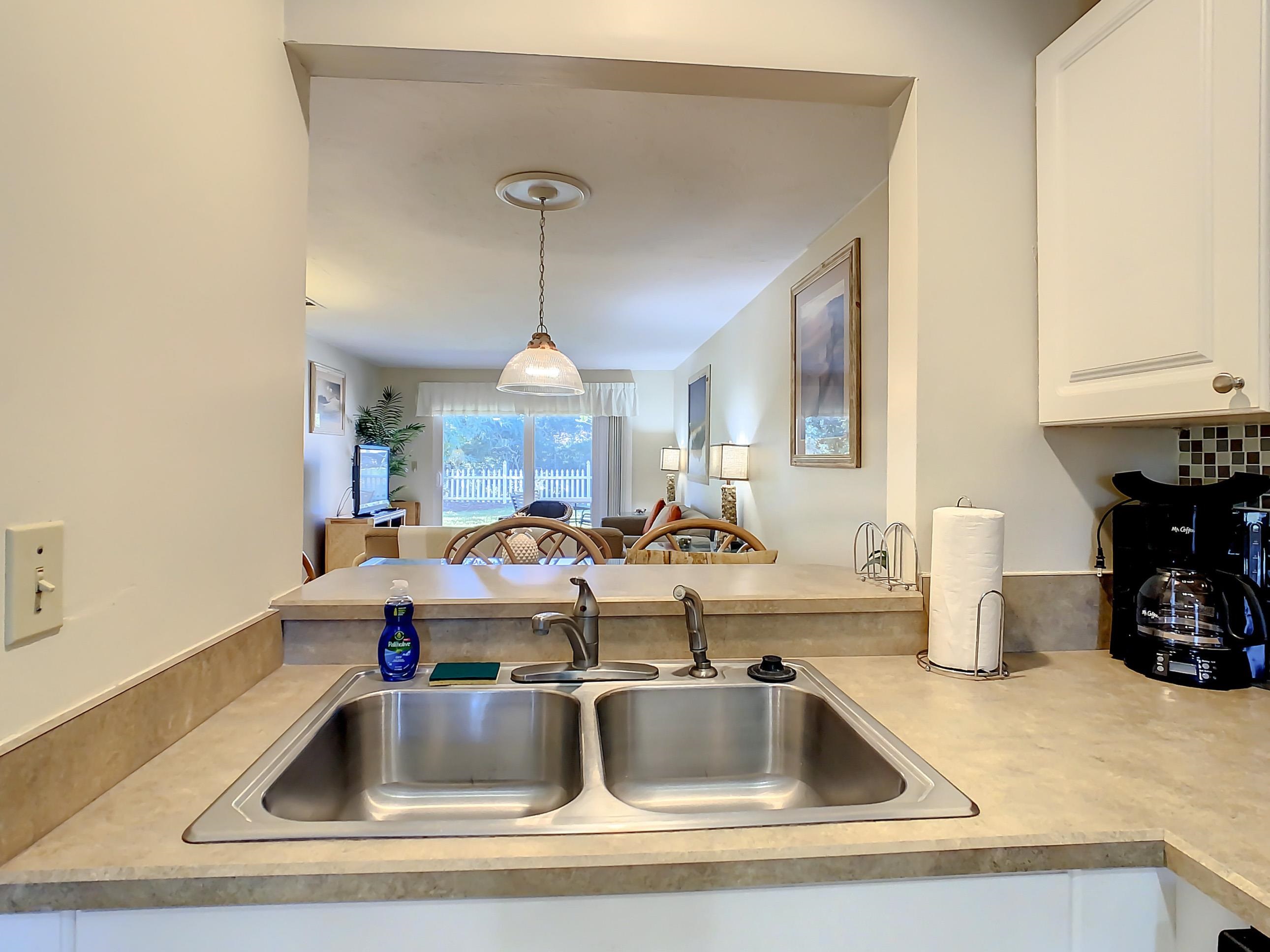 4 Ocean Trace Road, Unit 5 St. Augustine, FL 32080 - Photo 12 of 35 a kitchen with a sink a counter and chairs