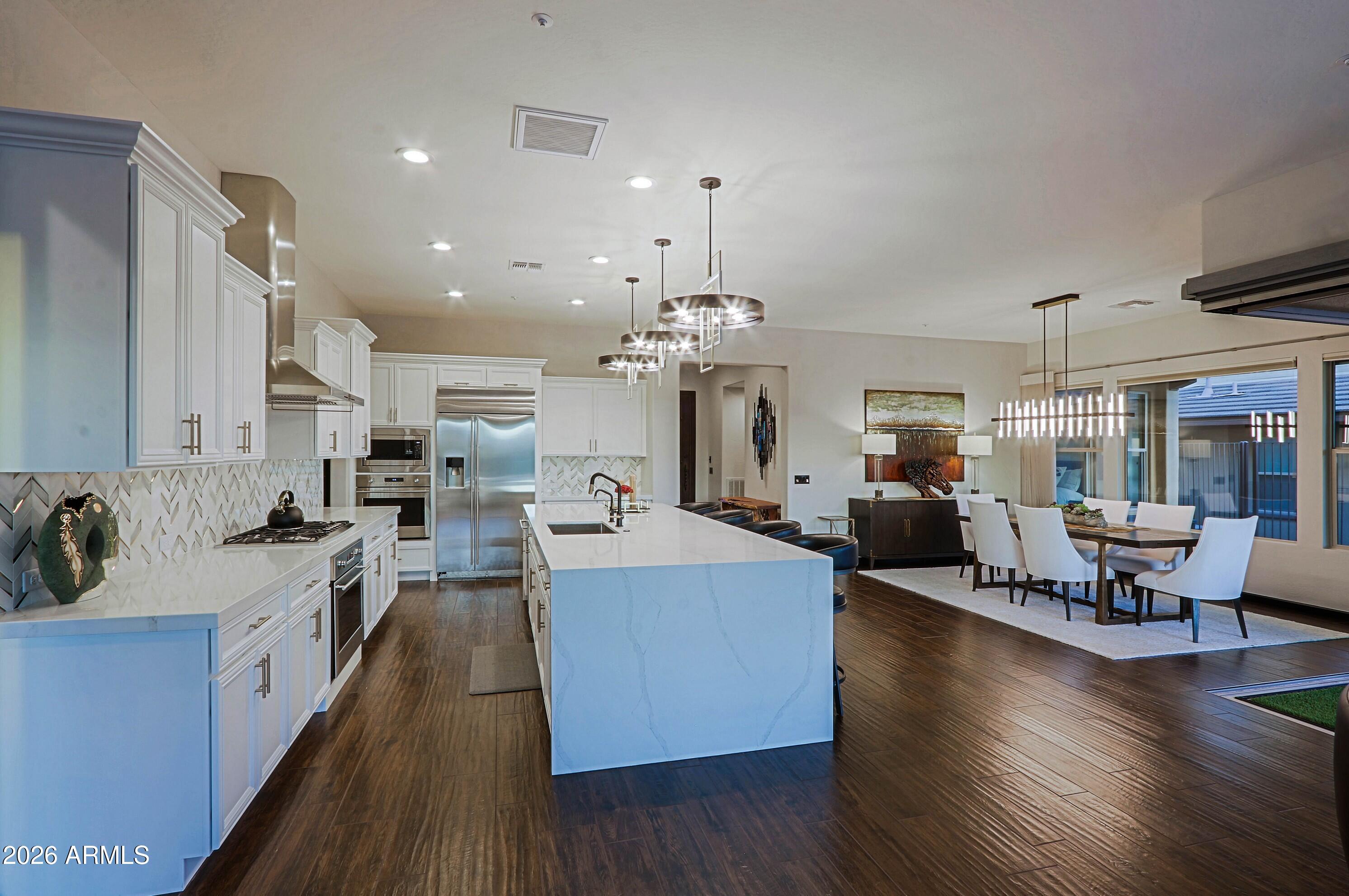 17623 East Fort Verde Road Rio Verde, AZ 85263 - Photo 11 of 57 a large kitchen with cabinets a sink dishwasher a dining table and chairs with wooden floor