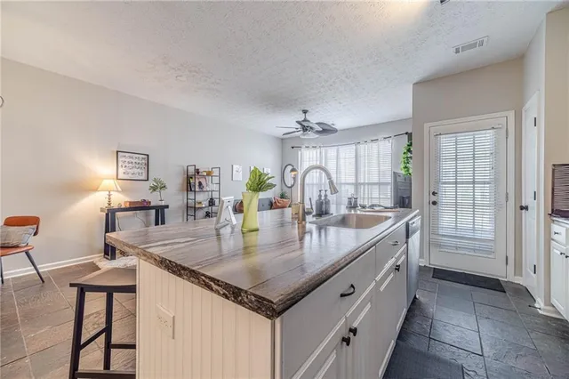 a kitchen with granite countertop a table chairs and stove