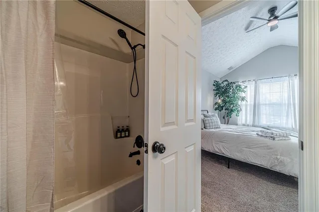 a bathroom with a tub shower and sink