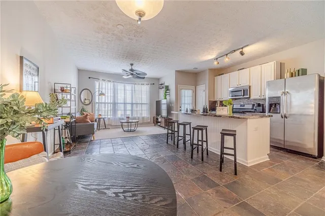 a large white kitchen with lots of counter space and stainless steel appliances