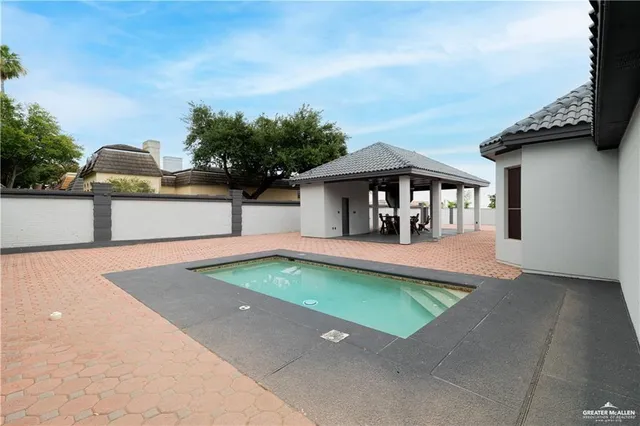 a view of a swimming pool with a patio and a yard