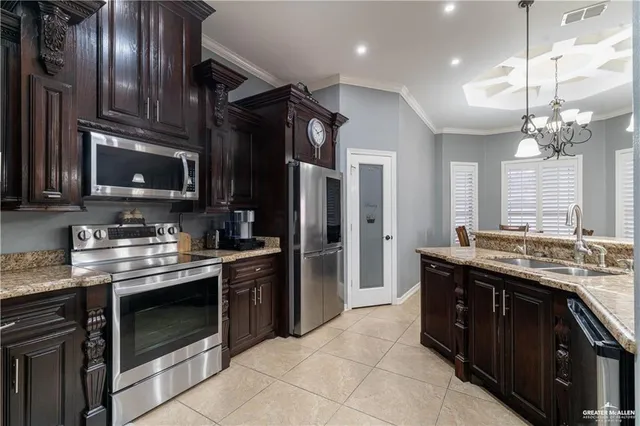 a kitchen with stainless steel appliances granite countertop a stove a sink and a refrigerator