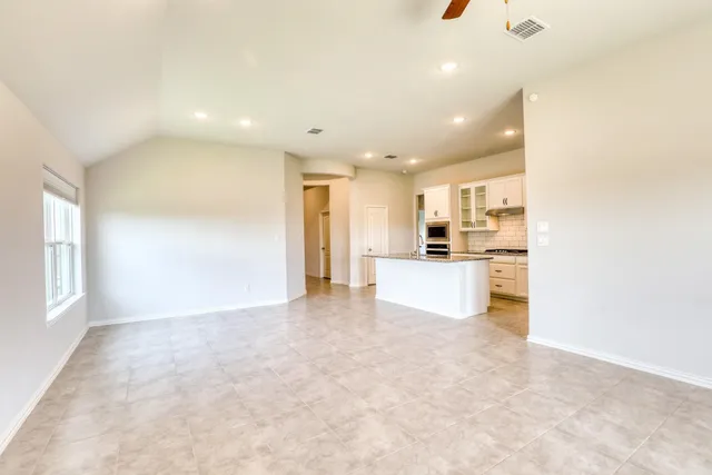 a view of a kitchen with kitchen island and stainless steel appliances