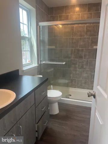 a bathroom with a granite countertop sink mirror toilet and bathtub