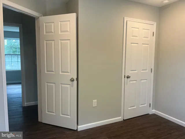 an empty room with wooden floor & wooden door