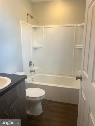 a bathroom with a granite countertop toilet a sink and bathtub