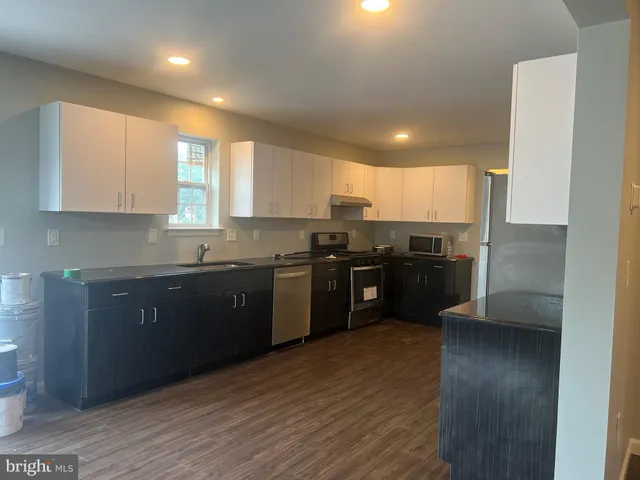 a kitchen with granite countertop stainless steel appliances refrigerator sink and cabinets