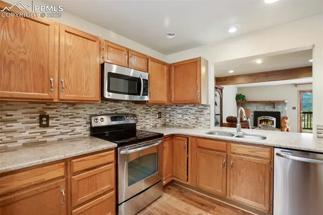 a kitchen with granite countertop cabinets stainless steel appliances and a sink