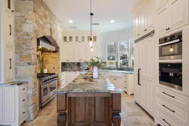 a kitchen with stainless steel appliances granite countertop a stove and refrigerator