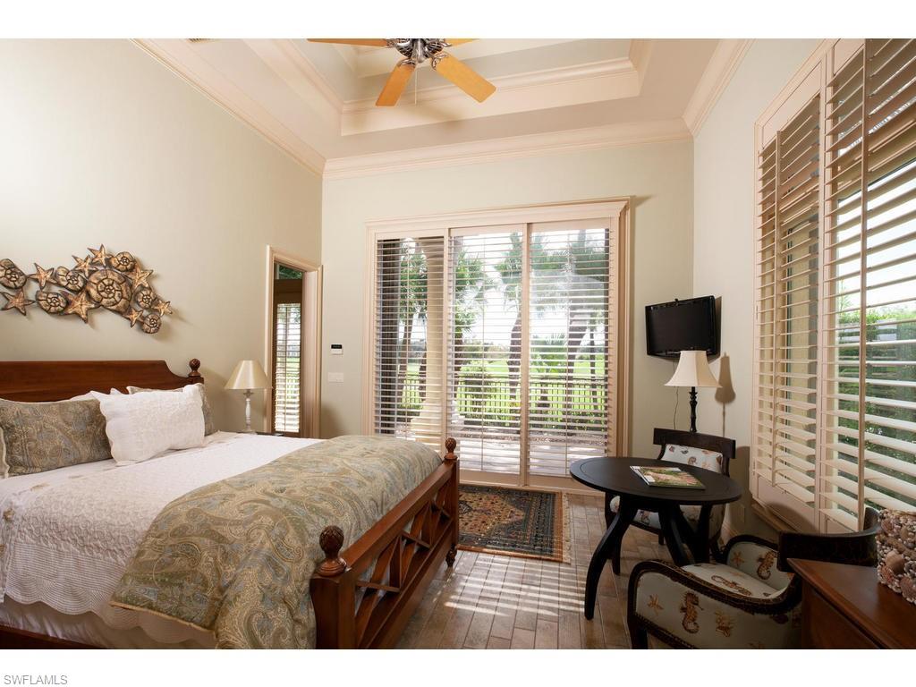 8631 Blue Flag Way Naples, FL 34109 - Photo 11 of 18 a bedroom with a bed and a table