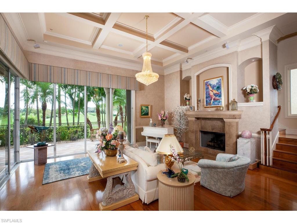 8631 Blue Flag Way Naples, FL 34109 - Photo 4 of 18 a living room with furniture a fireplace and a floor to ceiling window