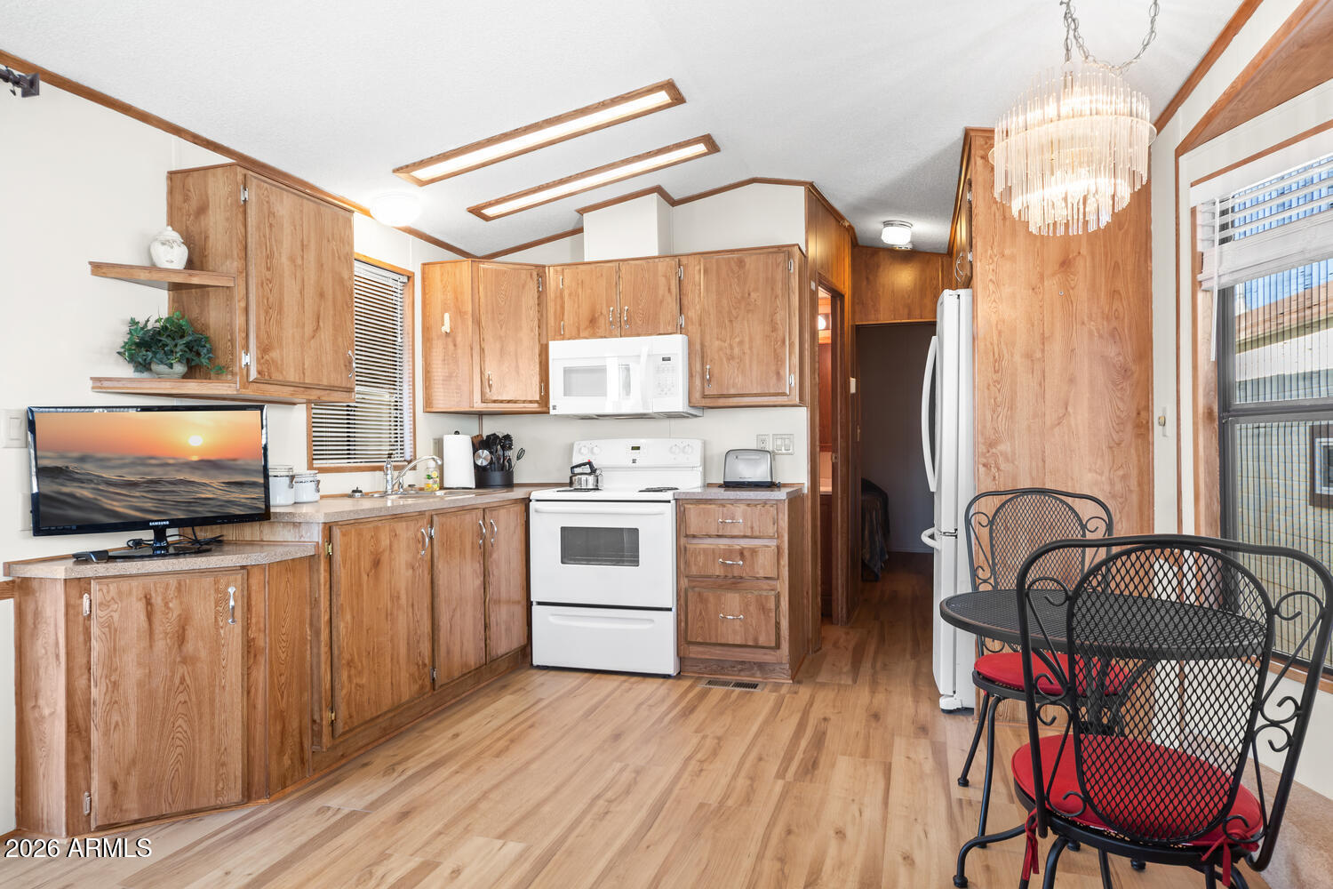 17200 West Bell Road, Unit 652 Surprise, AZ 85374 - Photo 11 of 19 a kitchen with stainless steel appliances a stove a sink and white cabinets
