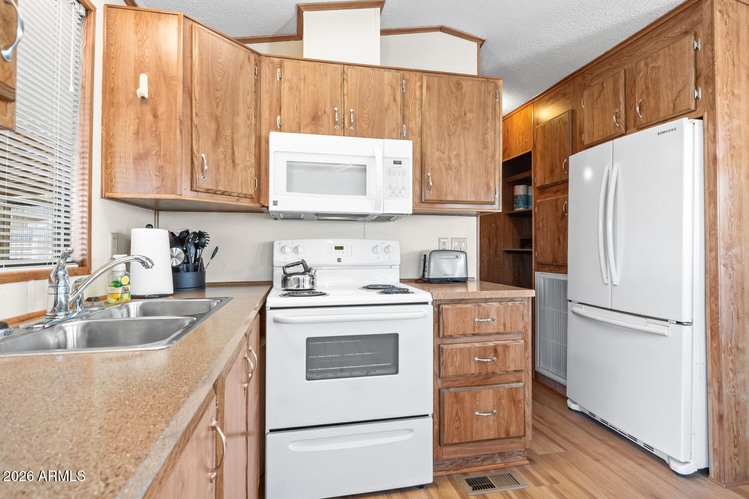17200 West Bell Road, Unit 652 Surprise, AZ 85374 - Photo 3 of 19 a kitchen with a stove a sink and a refrigerator
