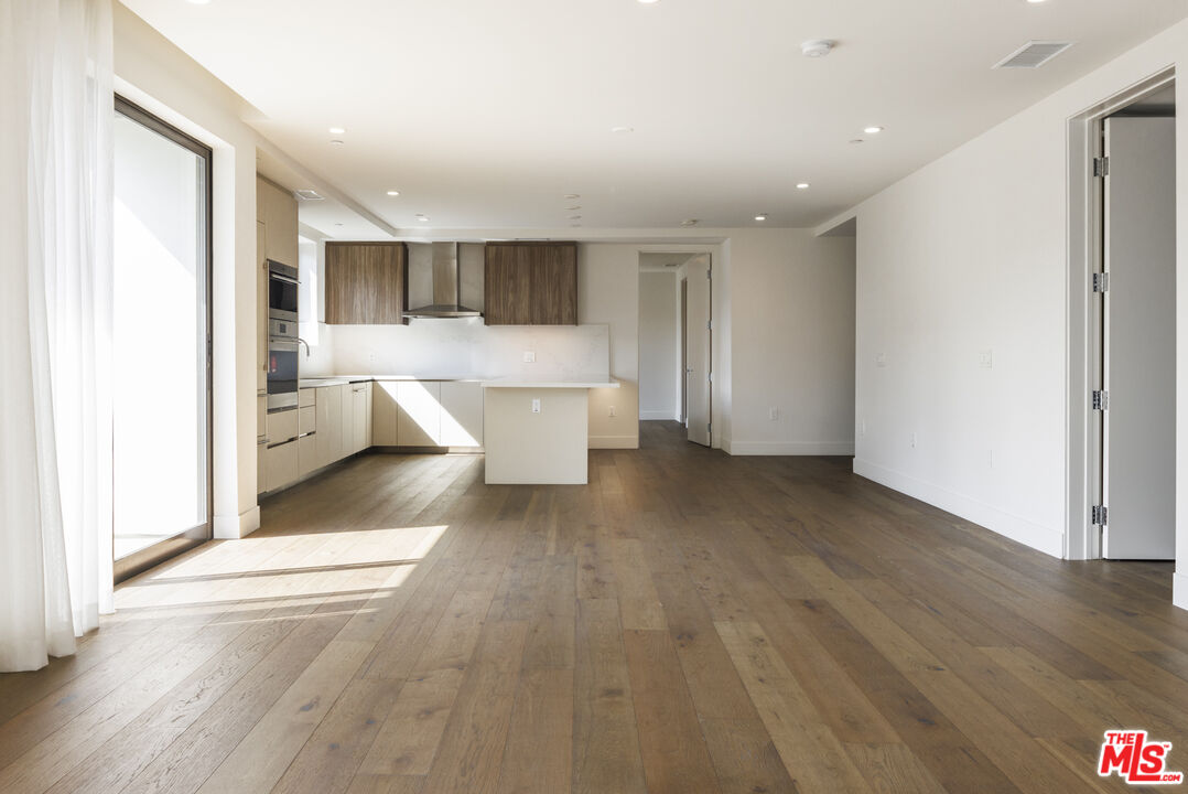 a view of a living room hardwood floor and a window