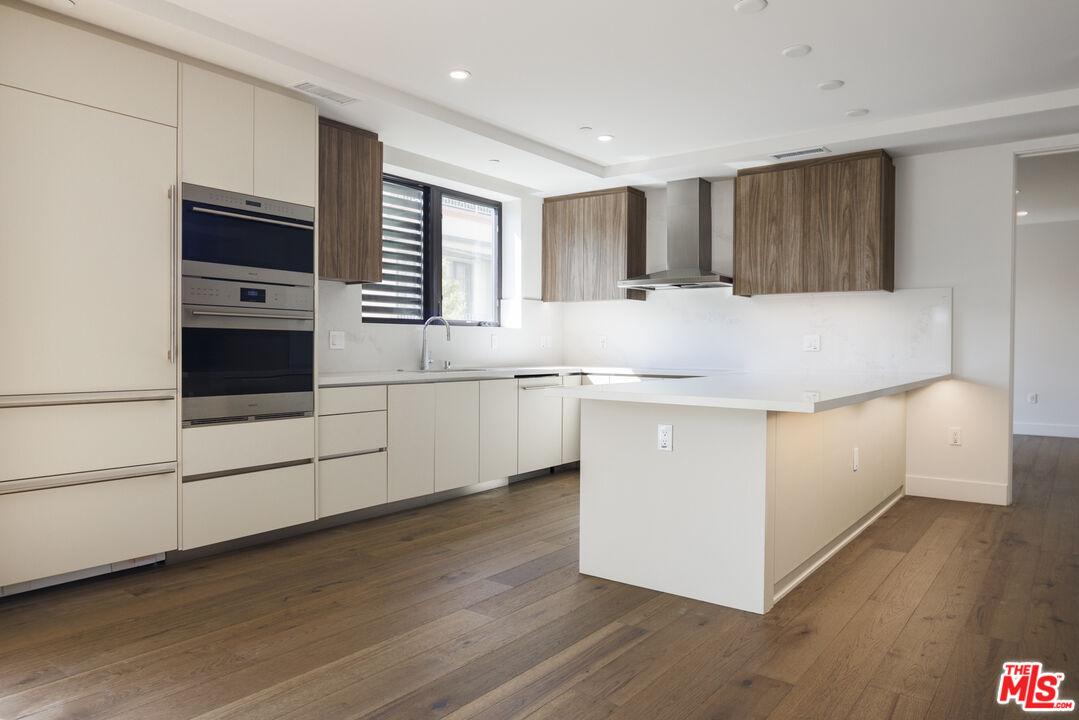 411 South Hamel Road, Unit 308 Los Angeles, CA 90048 - Photo 2 of 15 a kitchen with stainless steel appliances granite countertop a white stove top oven and a refrigerator