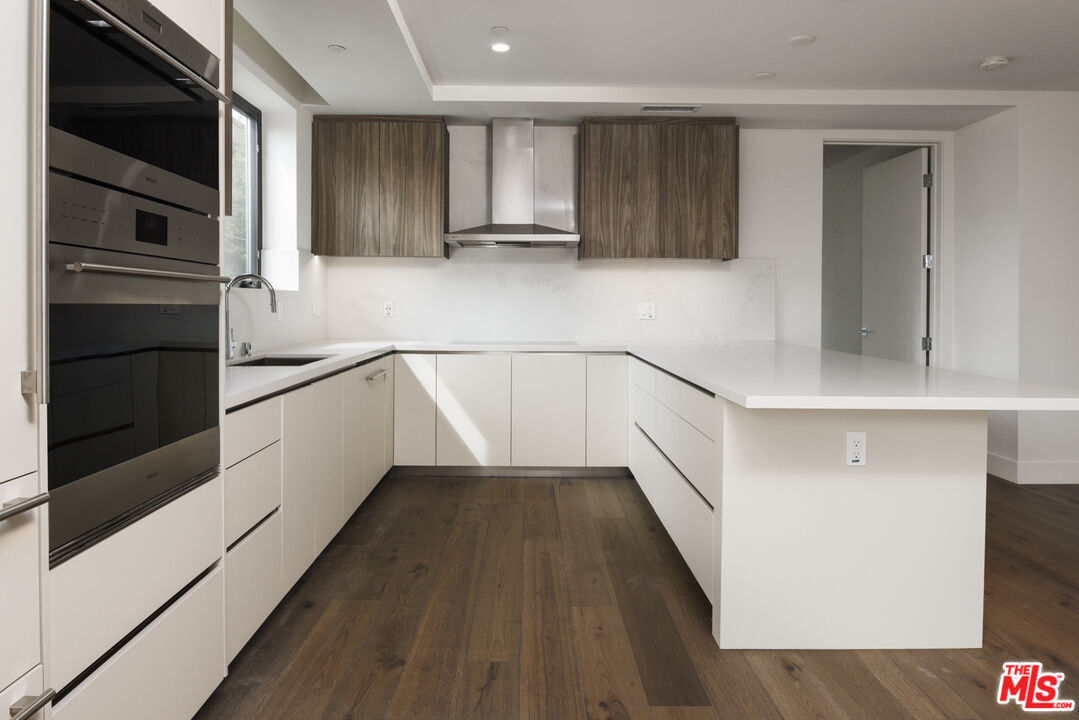 411 South Hamel Road, Unit 308 Los Angeles, CA 90048 - Photo 3 of 15 a kitchen with granite countertop stainless steel appliances and wooden cabinets