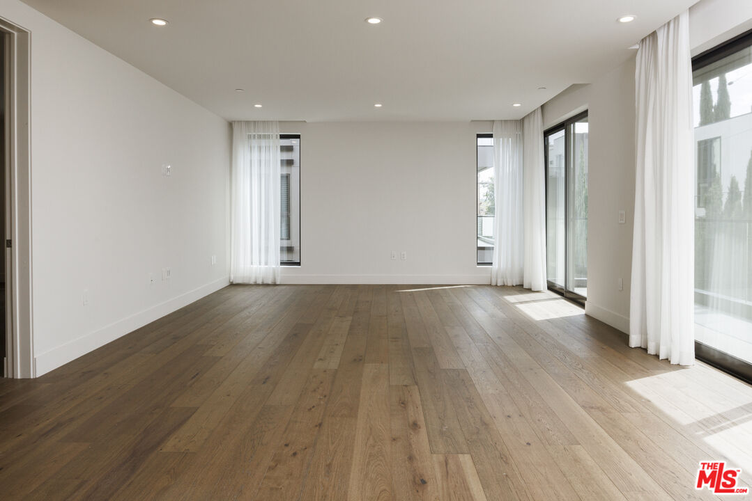 411 South Hamel Road, Unit 308 Los Angeles, CA 90048 - Photo 4 of 15 an empty room with wooden floor and windows