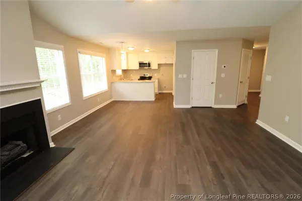 a view of a kitchen with wooden floor and electronic appliances