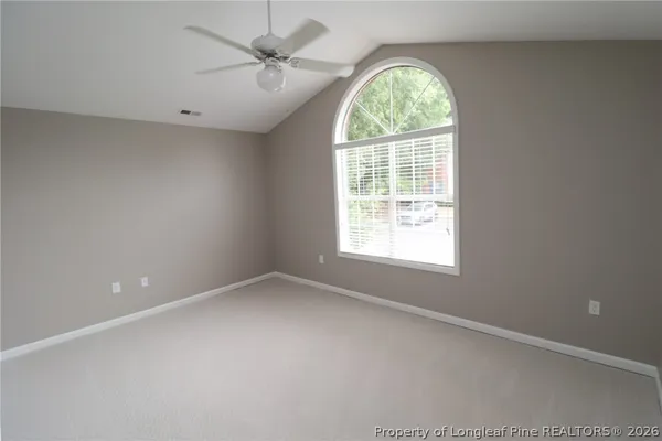 an empty room with a window and a fan