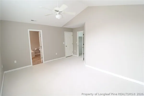 an empty room with a ceiling fan and a window