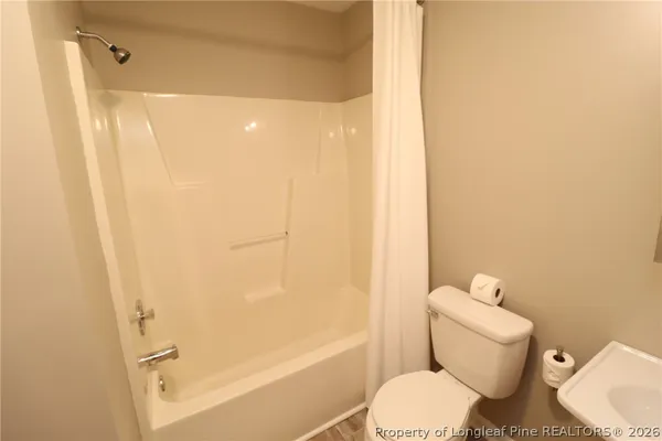 a white toilet sitting next to a bath tub