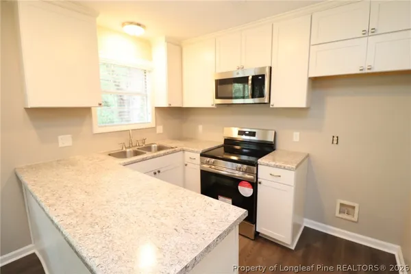 a kitchen with stainless steel appliances granite countertop a sink a stove and a microwave