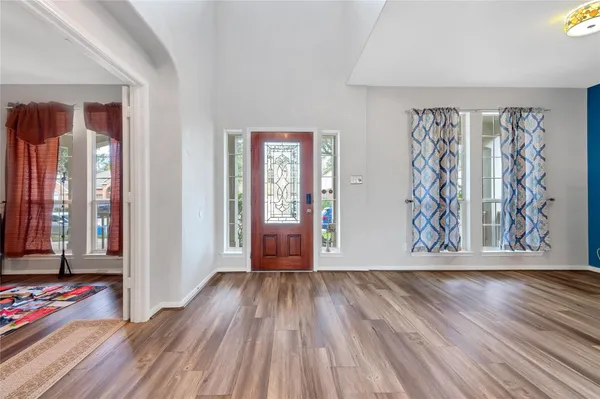 a view of an empty room with window and wooden floor