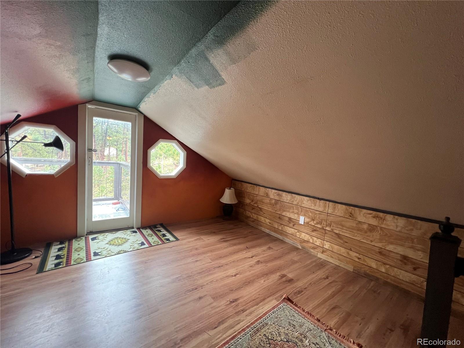 187 Johnson Road Bailey, CO 80421 - Photo 16 of 37 a view of an empty room with a window and wooden floor