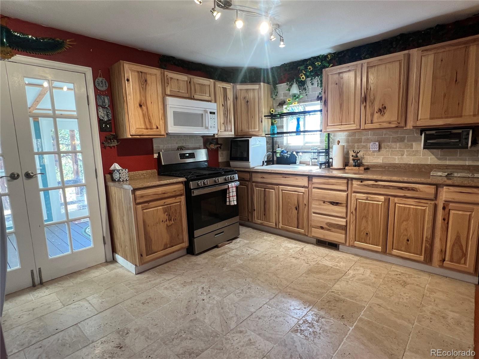 187 Johnson Road Bailey, CO 80421 - Photo 5 of 37 a kitchen with stainless steel appliances granite countertop wooden cabinets a sink and dishwasher