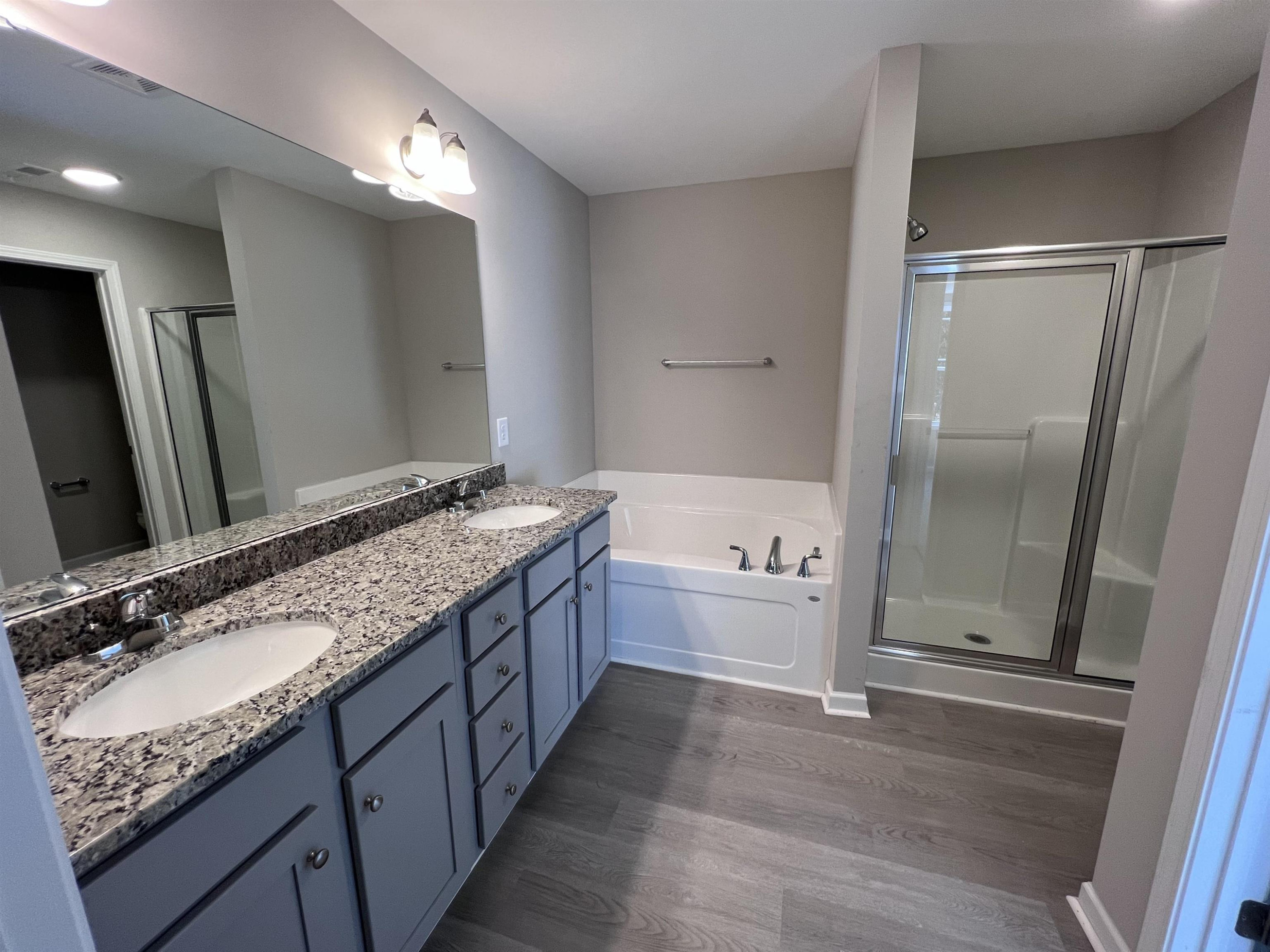 346 Touchdown Way Benson, NC 27504 - Photo 9 of 16 a bathroom with a granite countertop bathtub a sink and a mirror