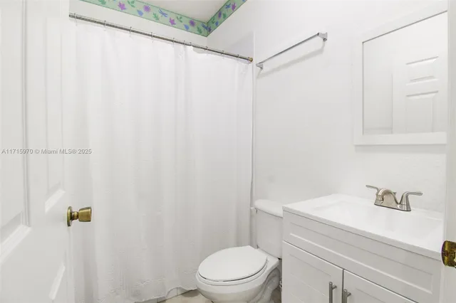a bathroom with a sink a toilet and shower curtain