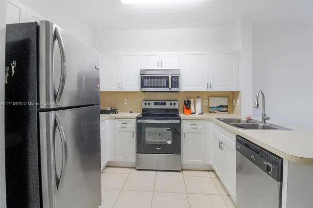 a kitchen with stainless steel appliances granite countertop a refrigerator sink and stove