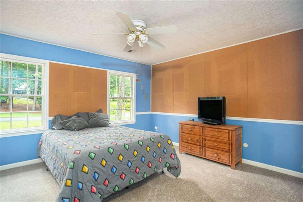 3838 Hunting Ridge Drive Southwest Lilburn, GA 30047 - Photo 32 of 56 a bedroom with a bed and a tv