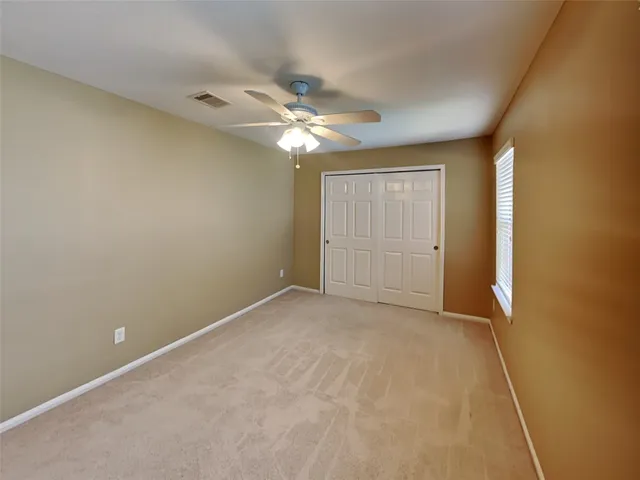 a view of an empty room with a ceiling fan