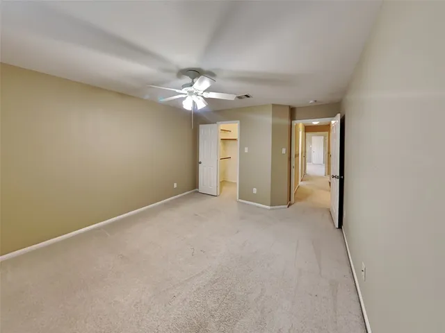 an empty room with chandelier fan