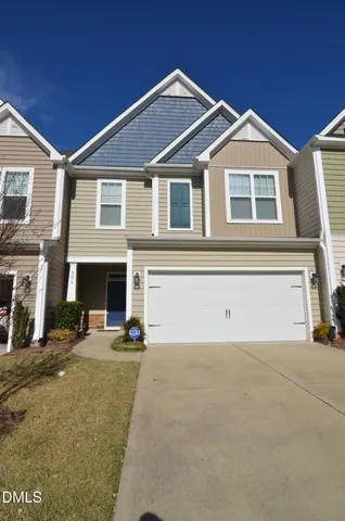 a front view of a house with yard and parking