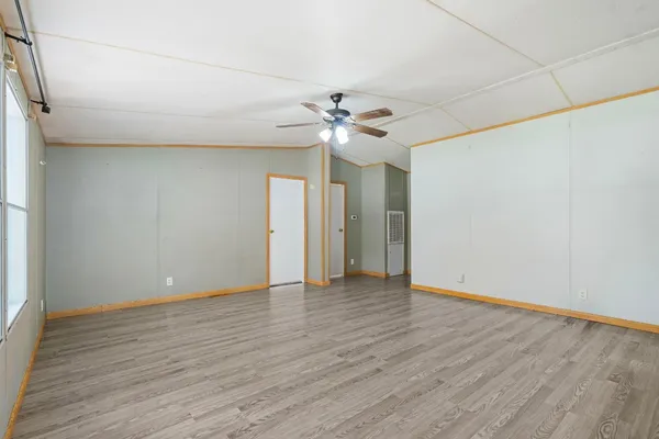 a view of an empty room with window and wooden floor
