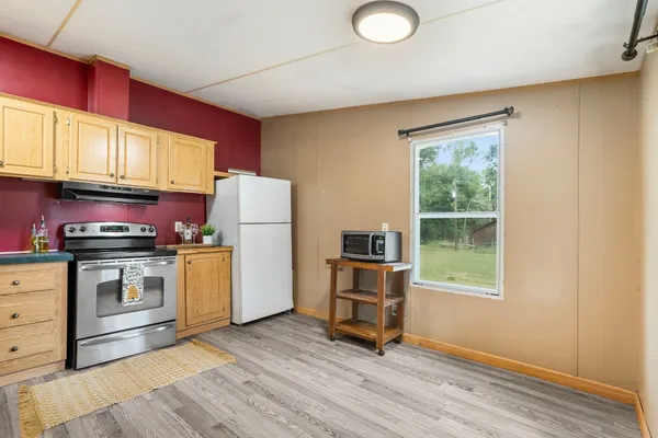 a kitchen with a refrigerator stove and wooden cabinets