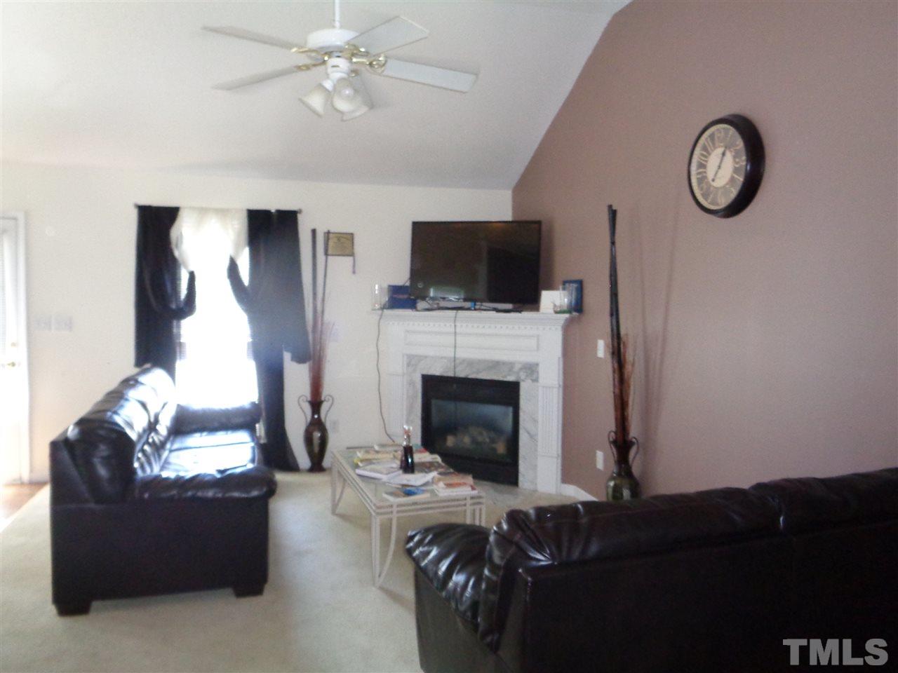 7124 Spanglers Spring Way Raleigh, NC 27610 - Photo 5 of 10 a living room with furniture a flat screen tv and a fireplace