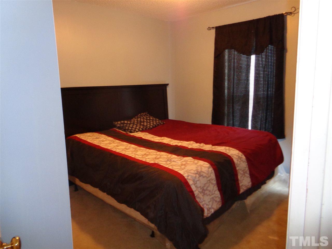 7124 Spanglers Spring Way Raleigh, NC 27610 - Photo 6 of 10 a bed sitting in a bedroom next to a window
