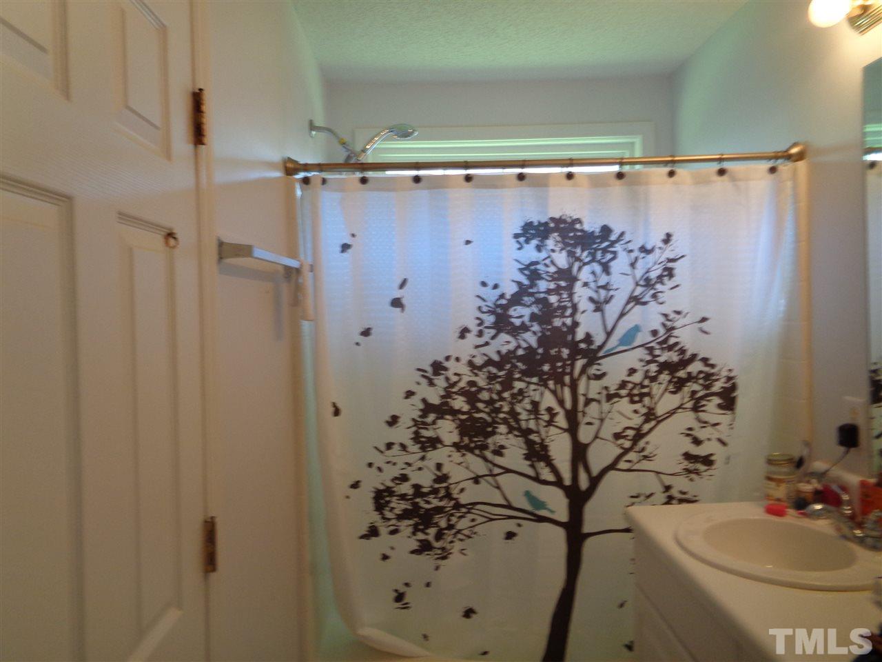 7124 Spanglers Spring Way Raleigh, NC 27610 - Photo 7 of 10 a bathroom with a shower curtain and sink