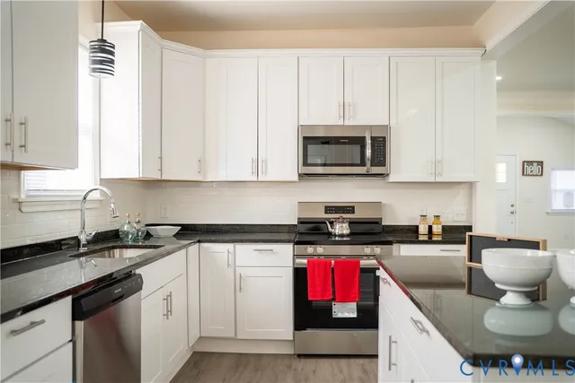 a kitchen with stainless steel appliances granite countertop a sink stove and cabinets