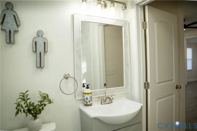 a bathroom with a sink and mirror with toilet