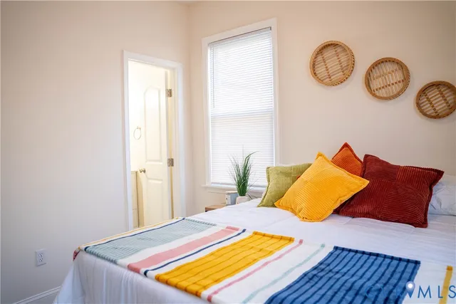 a bedroom with a bed and painting on the wall